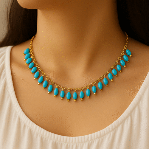 Model wearing a gold necklace with turquoise bead drops, crafted by H&A Jeweller