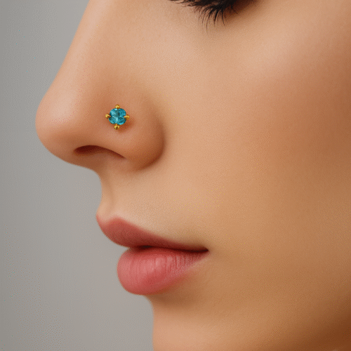 Close-up of a woman wearing a gold nose pin with a single ocean-blue gemstone by H&A Jewellery.